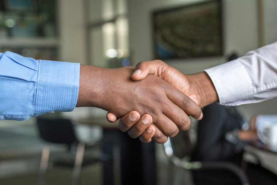 Business partners shaking hands over a desk